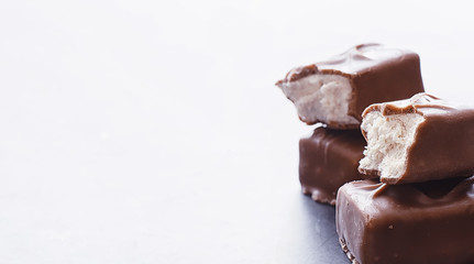 Chocolate bars on a black background in backlight. Chocolate with filling. Sweet sweets for snack and tea.