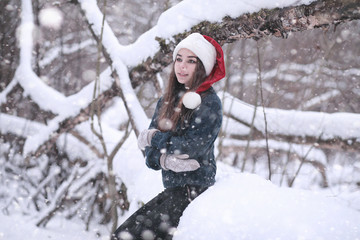 Girl in a winter park in snowfall