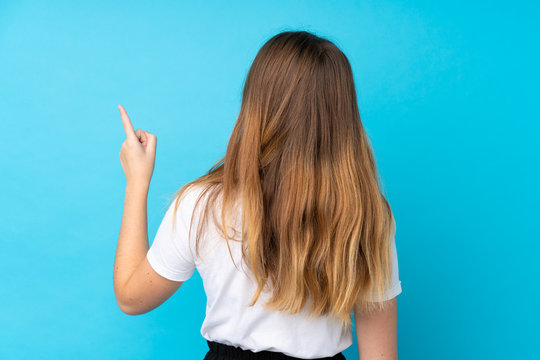 Ukrainian Teenager Girl Over Isolated Blue Background Pointing Back With The Index Finger