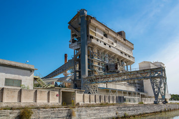 Fototapeta premium Eine Industrieanlage aufgenomme von der Flussseite aus.