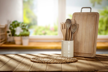 Fototapeta na wymiar Wooden desk in kitchen interior and blurred spring window space 