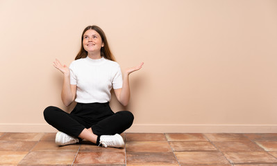 Ukrainian teenager girl sitting on the floor smiling a lot