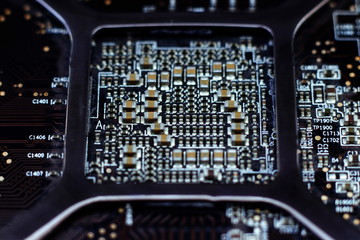 Close up macro on electronic system with integrated circuit chip and capacitors. Old board with dust