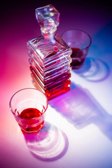 Glass square carafe with liquor with two glass glasses. View from above