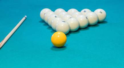 Green billiard table with white balls and cue