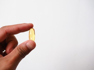 Hand holding Fish oil capsules, Cod liver oil omega 3 gel capsules, Vitamin And Dietary Supplements, Selective focus.