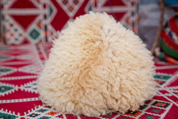 Caucasian peoples headdress made of sheep wool. Cossack hat . sheep wool mountain hats,beautiful mountain sheep hats,sheepskin hats on a background of carpet .