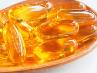 Fish oil capsules on white wooden background, Cod liver oil omega 3 gel capsules, Vitamin And Dietary Supplements.