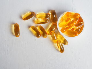 Fish oil capsules on white wooden background, Cod liver oil omega 3 gel capsules, Vitamin And Dietary Supplements.