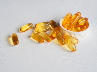 Fish oil capsules on white wooden background, Cod liver oil omega 3 gel capsules, Vitamin And...