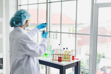 Asian scientists are preparing chemicals for testing and analysis in the laboratory. Scientists clear glasses and white shirts. Science and Chemistry Concept