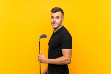 Golfer player man over isolated yellow background smiling a lot