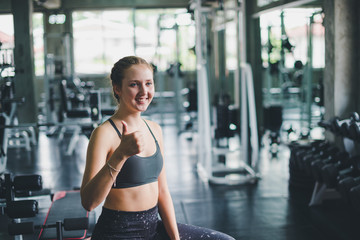 Fototapeta premium A beautiful young woman wearing a relaxing sports shirt with a rubber ball, yoga or exercise ball.