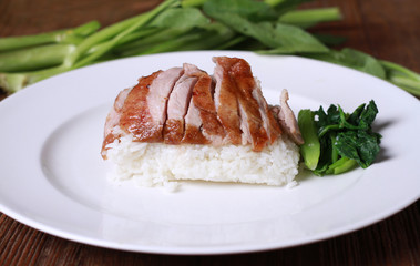 Rice with roast duck on wood table.