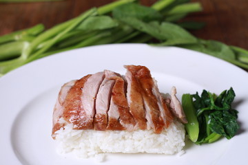 Rice with roast duck on wood table.