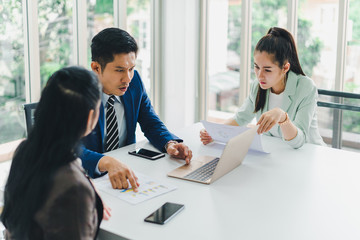 Managers and secretaries meeting and discussing business results from notebooks and paper charging statistics are in the company.