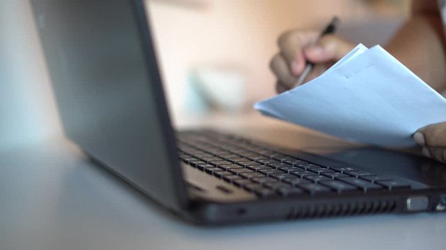Businesswoman writing notes learning on laptop computer technology Meeting plan concept: Asian Business people working document on laptop computer with documents in office