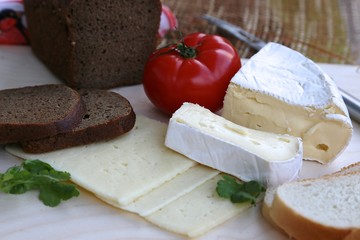 Red fresh round tomato, black bread cut into pieces and fresh white homemade cheese cut into large pieces