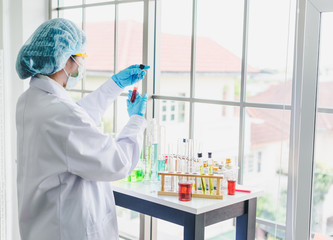 Asian scientists are preparing chemicals for testing and analysis in the laboratory. Scientists clear glasses and white shirts. Science and Chemistry Concept