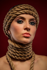 Portrait of a beautiful young woman with ropes