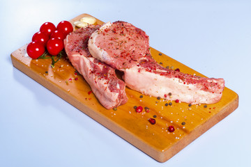 Raw beef meat and vegetables on a wooden board..
