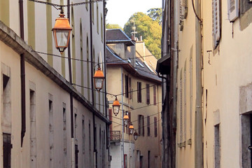 Fototapeta na wymiar A row of orange lanterns hanging along the narrow street of Chambery, France
