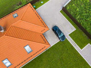 Top down aerial view of two private houses, one under construction with wooden roofing frame and...
