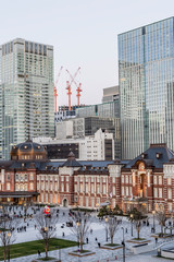 Obraz premium 東京都千代田区丸の内の夕方の東京駅と高層ビル群