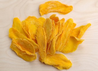 Mango fruit cut into long strips and dried in the sun, yellow lies on the board ready to eat for breakfast.
