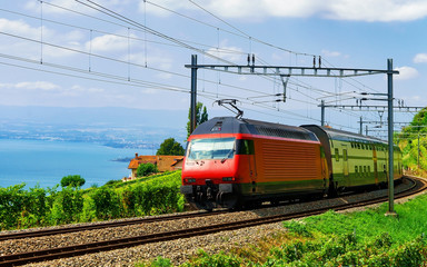 Fototapeta na wymiar Running train and the railroad at Lavaux Vineyard Terraces hiking trail at Lake Geneva and Swiss mountains, Lavaux-Oron district, Switzerland