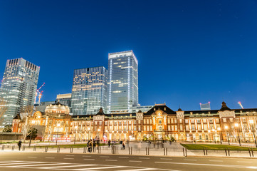 Fototapeta na wymiar 東京都千代田区丸の内の夜のライトアップした東京駅と高層ビル群