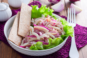 Pickled squid salad with onions, selective focus