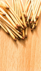 many wooden matches lie on a wooden background. flammable matches on a wooden table.