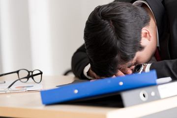 A businessman slept in the working time at the office.