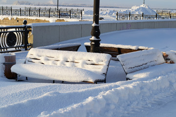 Winter landscape benches covered with snow on river