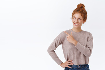 Curious attractive, elegant woman with red curly hair in bun check-out something interesting,...