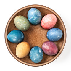 Different easter eggs in ceramic bowl isolated on white