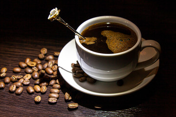 cup of hot coffee and coffee grains on the table