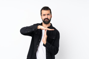 Young man with beard over isolated white background making time out gesture - obrazy, fototapety, plakaty