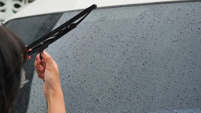 The woman's hand remove the old wiper of the car, Rainy season should always be changed or maintained by car wipers, For driving safety.