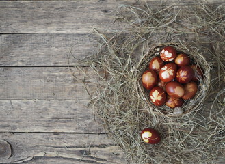 Christ is risen. Onion-painted eggs on dried grass in a nest. Traditional spring festive orthodox...