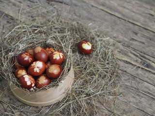 Christ is risen. Onion-painted eggs on dried grass in a nest. Traditional spring festive orthodox...