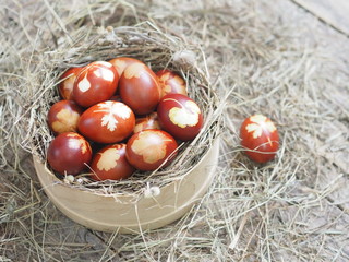 Christ is risen. Onion-painted eggs on dried grass in a nest. Traditional spring festive orthodox food. Easter Sunday.