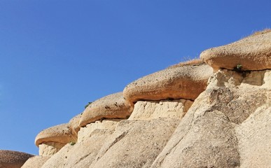 Amazing limestone rock formations in the Cappadocia region of Turkey. The combination of beige rocks and bright blue sky