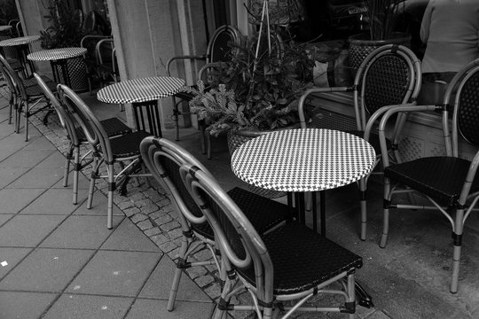 Runde Bistrotische mit Pepitamuster auf Gehweg und B&uuml;rgersteig vor einem Caf&eacute; und Bistro in der Braubachstra&szlig;e in der Altstadt von Frankfurt am Main in Hessen in neorealistischem Schwarzwei&szlig;