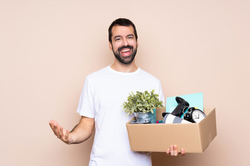 Man holding a box and moving in new home over isolated background smiling