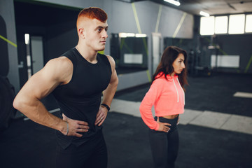 Guy and girl in the gym. A boy and girl perform exercises.Sports people in the gym