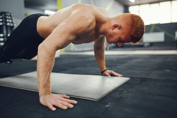 Fototapeta premium Man in the gym. Muscular guy.Man performs exercises