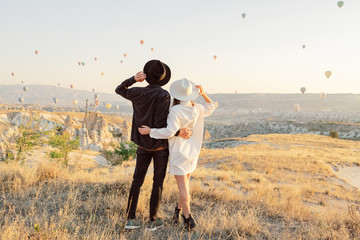 Wedding travel. Honeymoon trip. Couple in love among balloons. A guy proposes to a girl. Couple in love in Cappadocia. Couple in Turkey. Man and woman traveling. Flying on balloons. Tourists