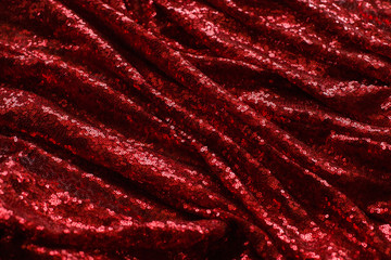 bright red fabric with small round sequins, with metallic sheen laid out by waves for Valentine's day